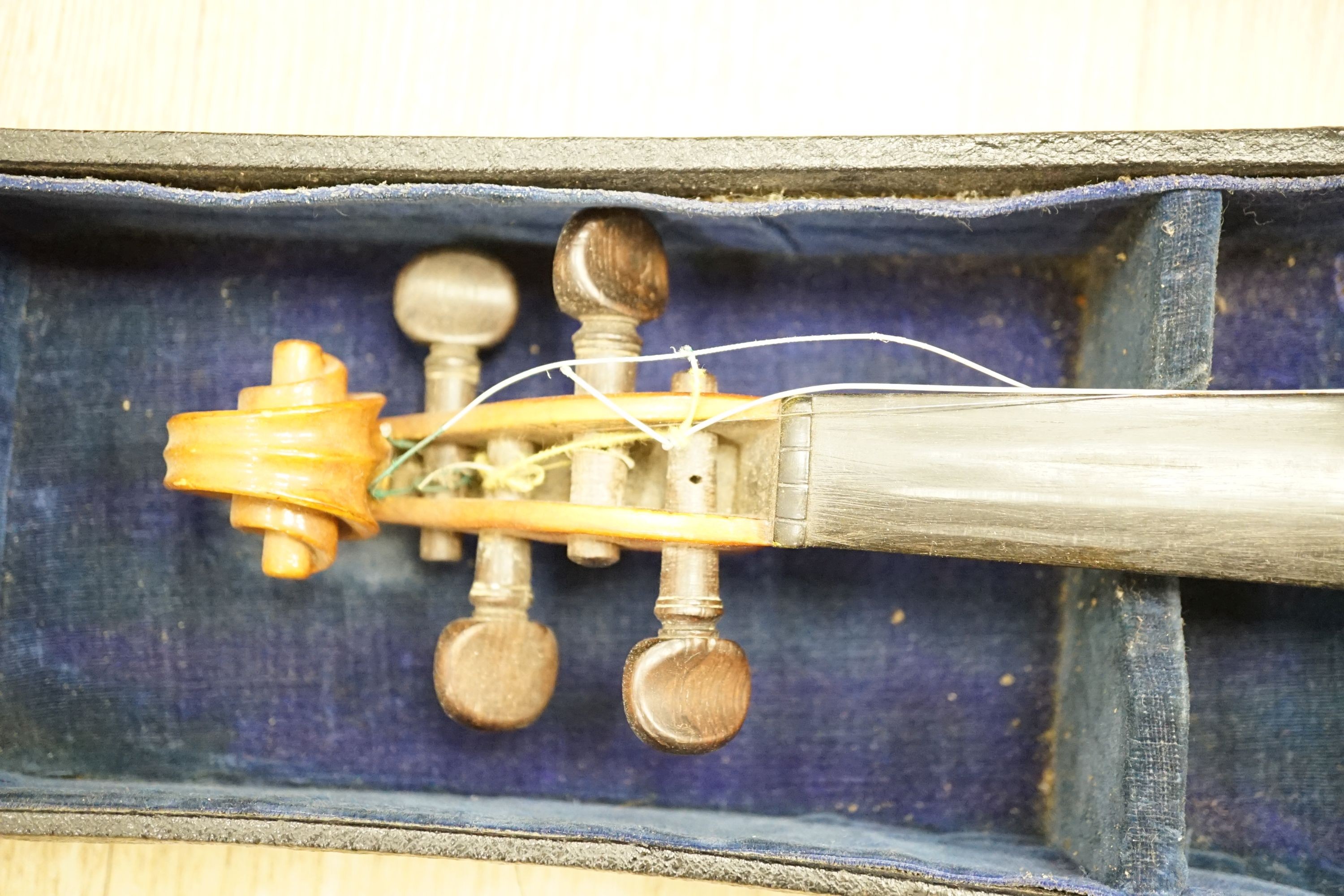 A cased violin, 60 cms long.